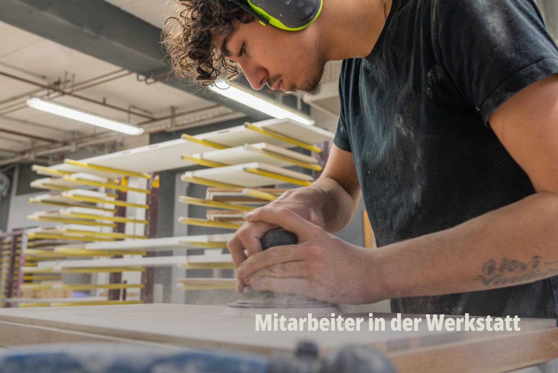 Junger Schreiner der Bard AG trägt Lärmschutzkopfhörer und schleift und poliert Holz; Employer Branding durch SR-STUDIOS. | SR-STUDIOS