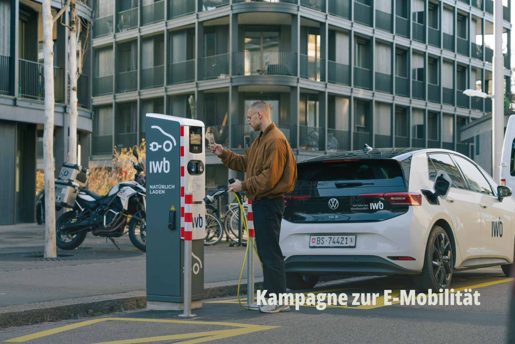 Lifestyle Aufnahme einer Person, die ihr Elektroauto an einer urbanen IWB Ladestation in Basel auflädt. | SR-STUDIOS