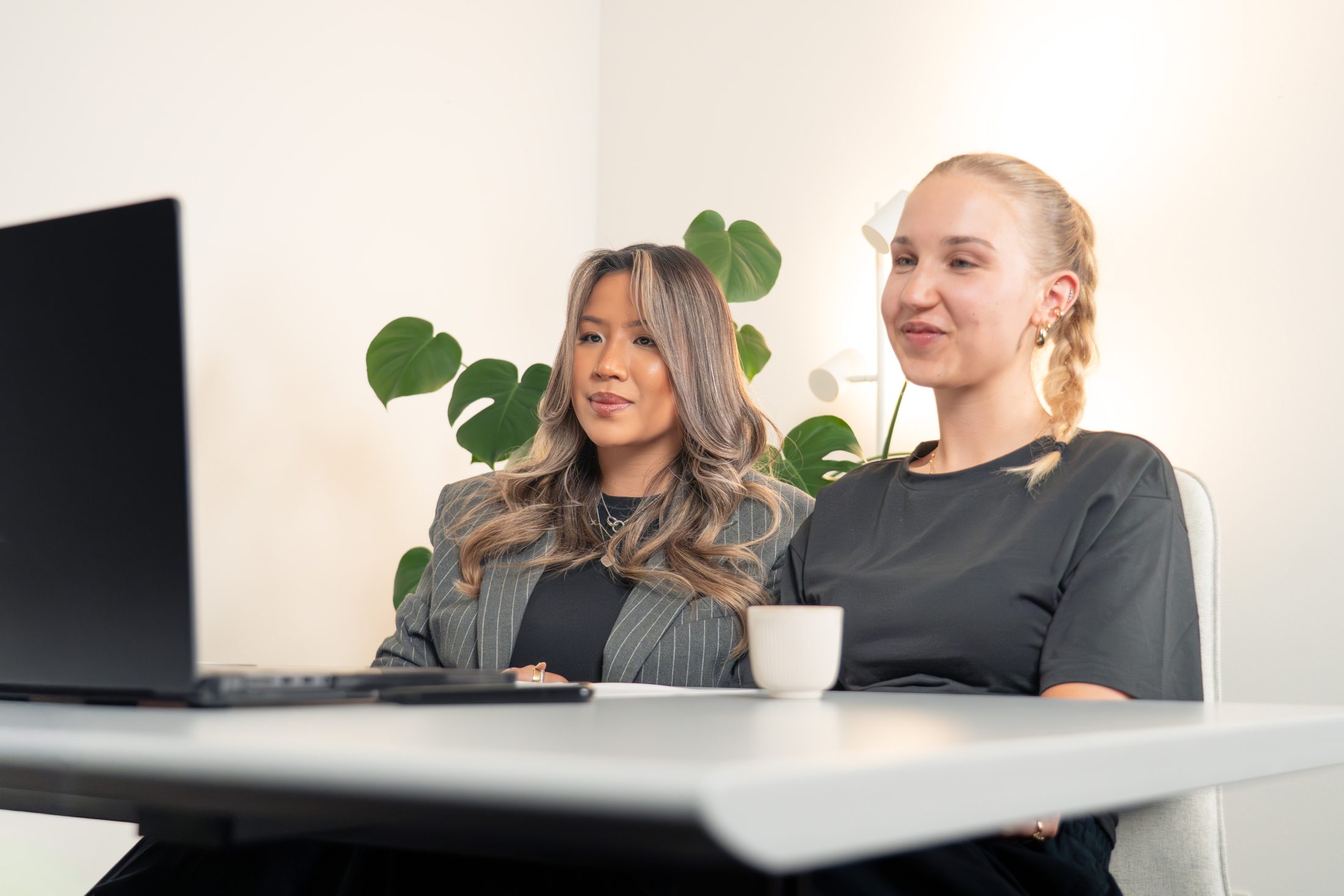 Zwei Mitarbeiterinnen des Internal Marketing von SR-STUDIOS sitzen vor einem Computerbildschirm im Büro und halten ein Interview Gespräch mit Creator July (@julyanpohl) über Community Management. | SR-STUDIOS