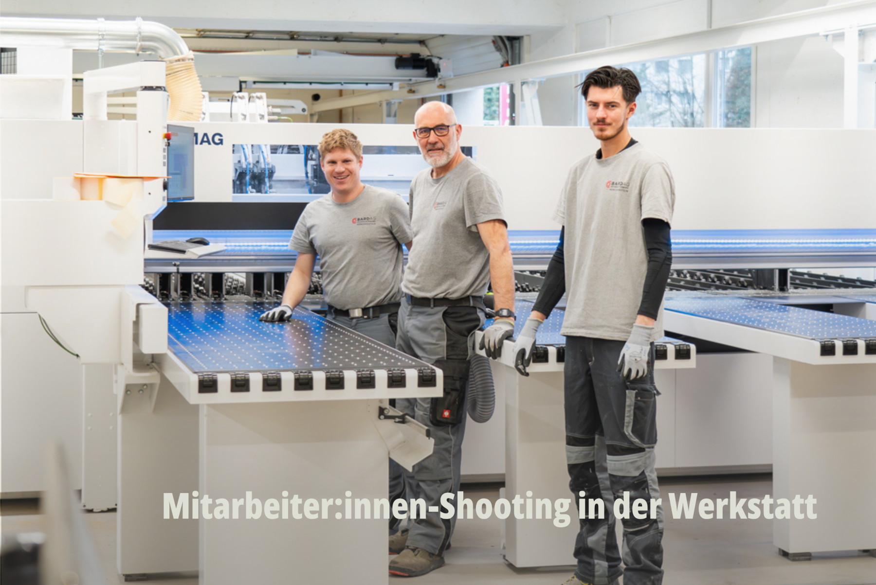 Drei Mitarbeiter, Spezialisten und Schreiner der Bard AG stehen in Arbeitsklamotten in der Werkstatt und bedienen die Zuschnittmaschine. Effiziente Produktion und modernster Maschinenpark für Grossprojekte in der Schweiz. | SR-STUDIOS