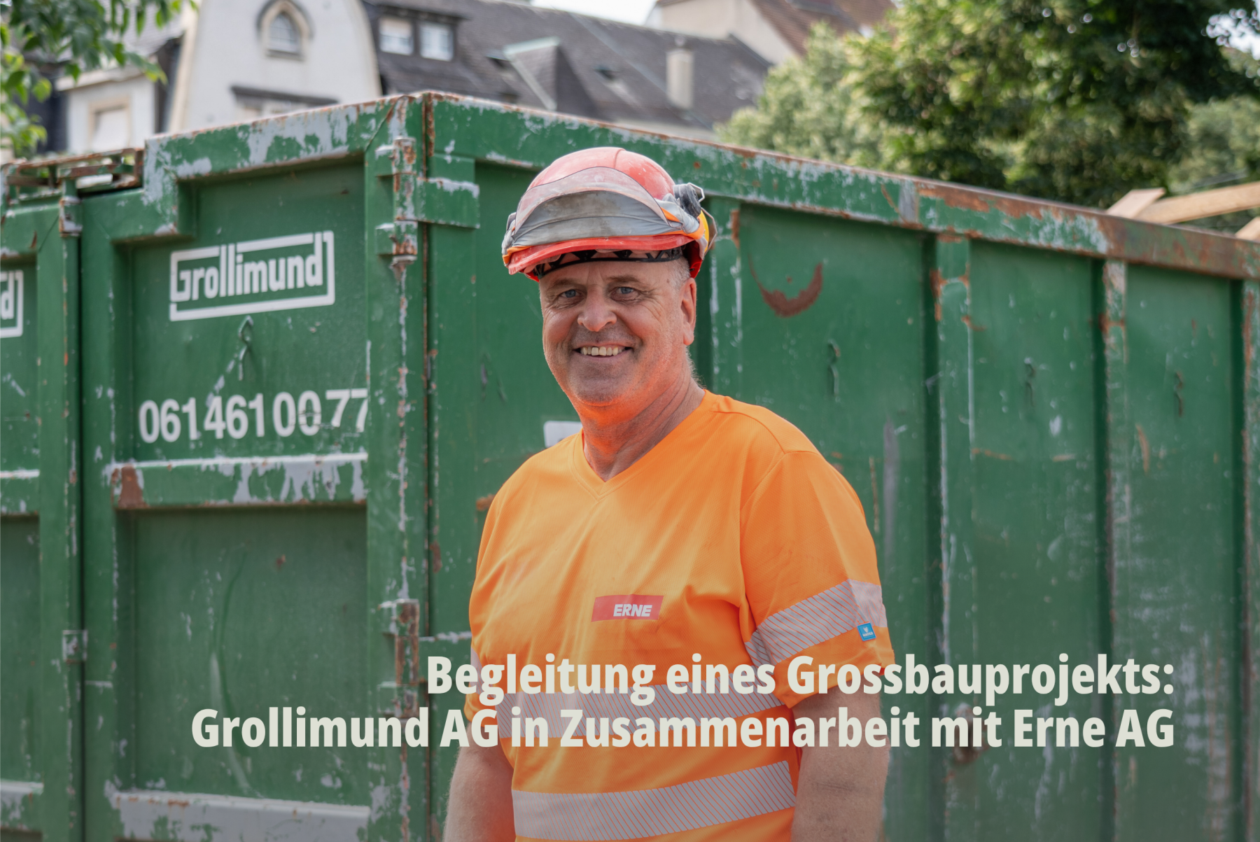 Porträt eines lächelnden Mitarbeiters der Erne AG in Warnweste vor einem grünen Abrollcontainer der Grollimund AG. | SR-STUDIOS