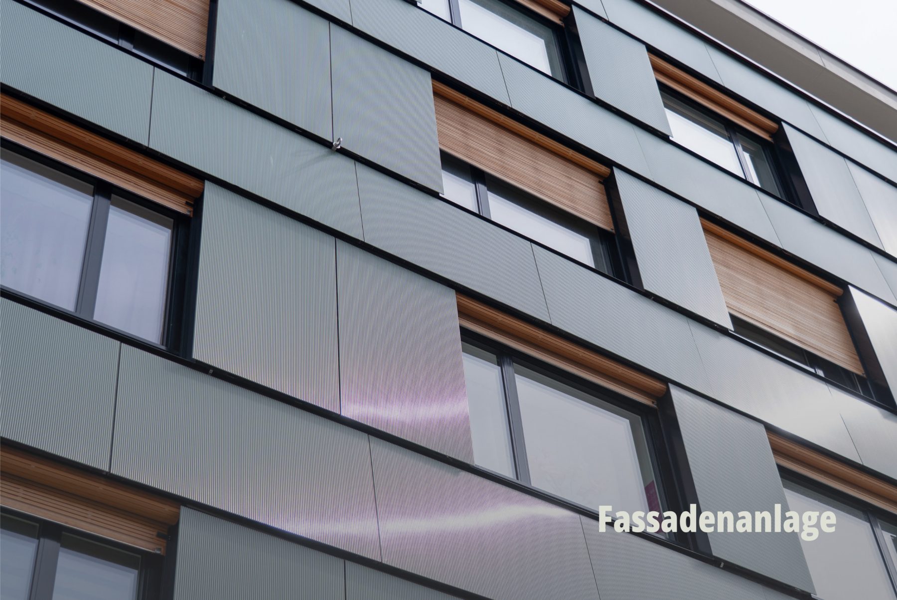 Architekturfotografie einer modernen Gebäudefassade mit integrierten Photovoltaik-Elementen und eleganten Fensterfronten; Planeco GmbH. | SR-STUDIOS