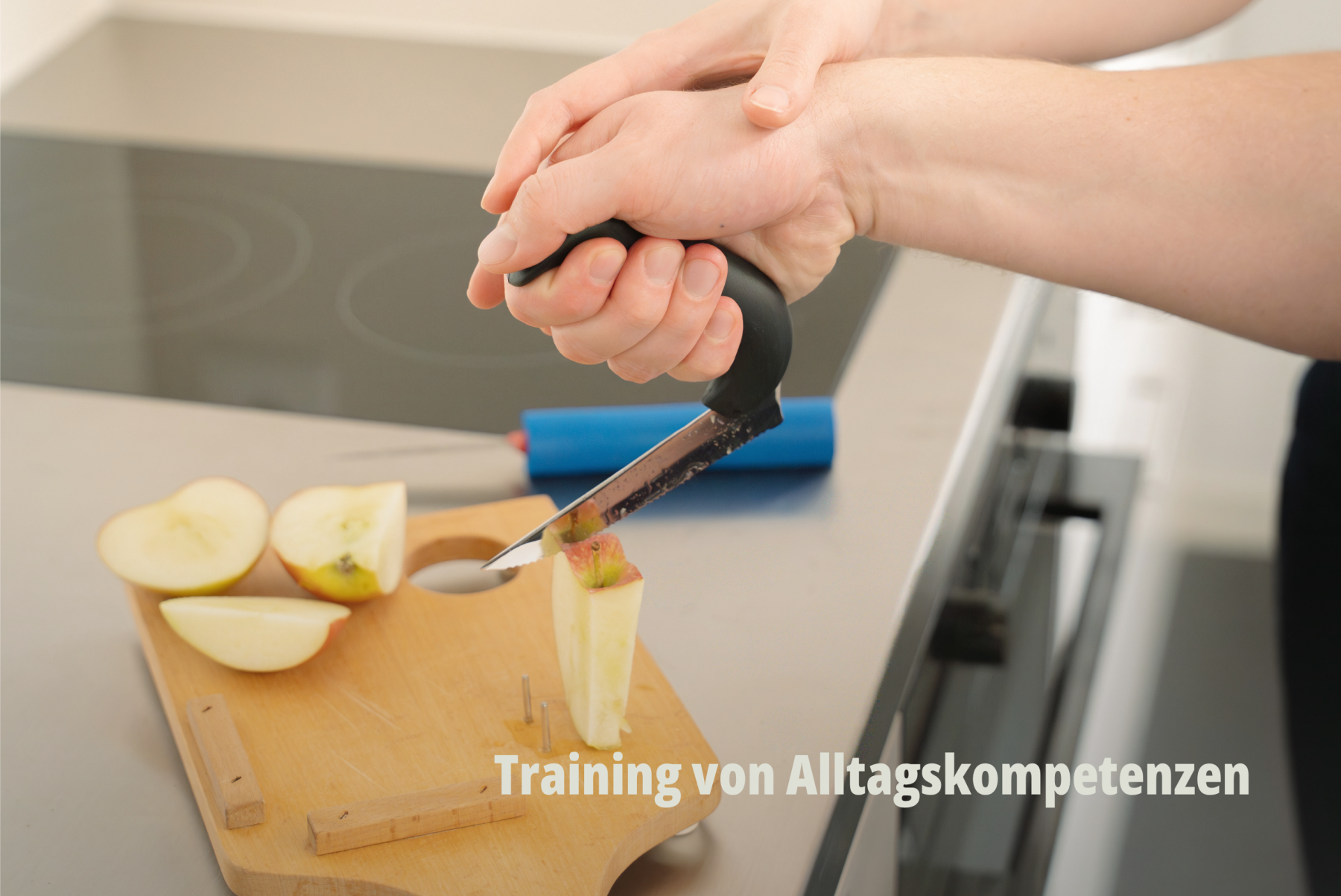Alltagsnahe Fotografie einer Ergotherapie-Situation: Unterstützung beim Schneiden von Obst mit speziellen Hilfsmitteln in einer modernen Küche; RehaCity Basel. | SR-STUDIOS