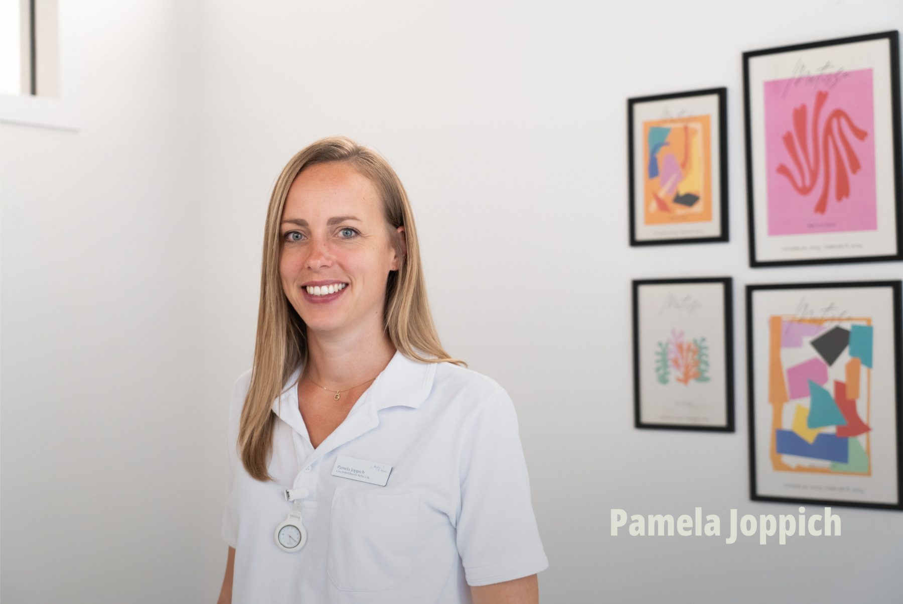Sympathisches Mitarbeiterinnen-Porträt einer lächelnden Physiotherapeutin in weisser Arbeitskleidung; Employer Branding; RehaCity Basel. | SR-STUDIOS