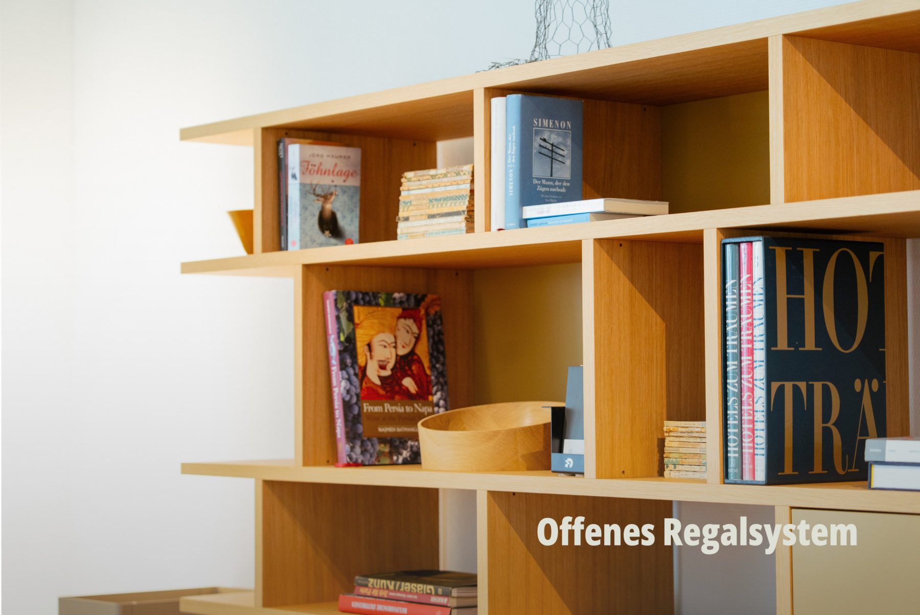 Detailansicht eines hellen Holzregals mit Büchern, das die Präzision der Kantenführung hervorhebt; vifian. | SR-STUDIOS