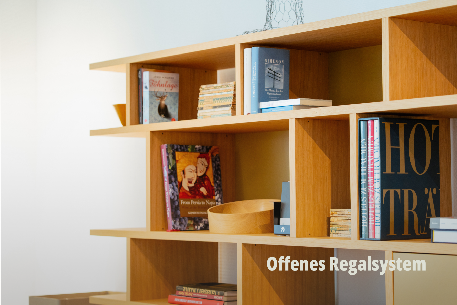 Detailansicht eines hellen Holzregals mit Büchern, das die Präzision der Kantenführung hervorhebt; vifian. | SR-STUDIOS