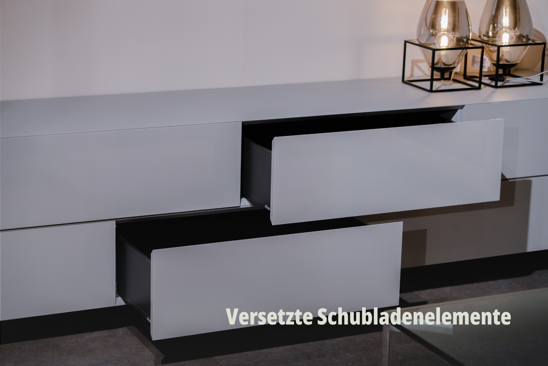 Abstrakt wirkende Detailaufnahme von verschachtelten, grifflosen Schubladenelementen in kühlem Weiss; vifian. | SR-STUDIOS