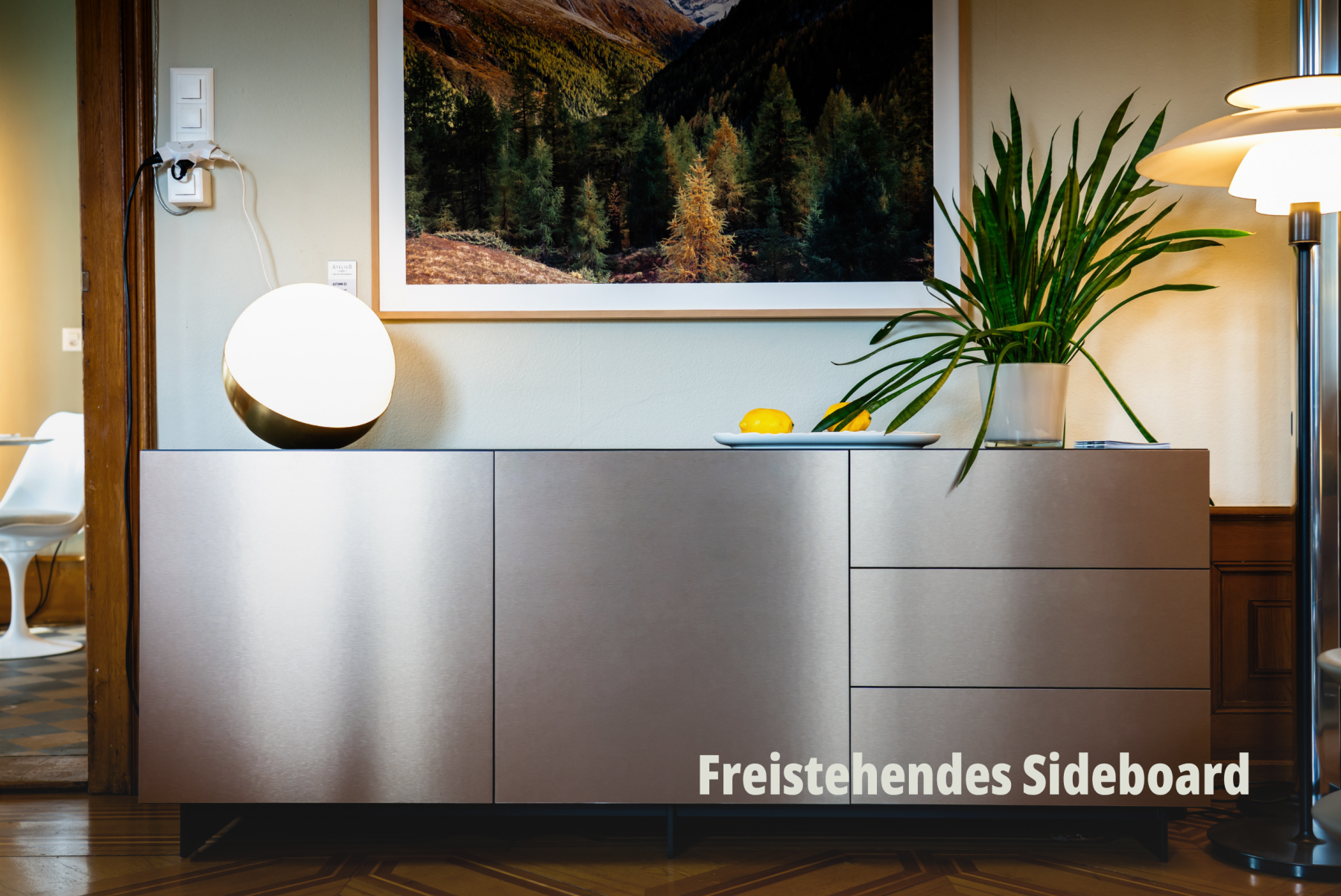 Symmetrische Produktfotografie eines metallisch schimmernden Sideboards mit dekorativer Beleuchtung und Zimmerpflanze; vifian. | SR-STUDIOS