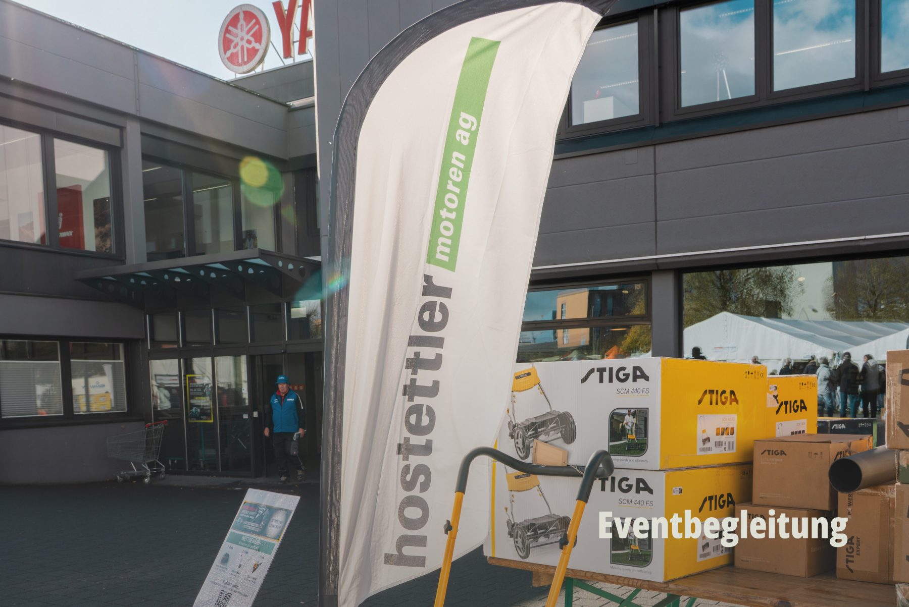 Aussenansicht eines Gebäudes mit Branding Fahnen der hostettler motoren ag; Lifestyle Fotografie von SR-STUDIOS während eines Events. | SR-STUDIOS