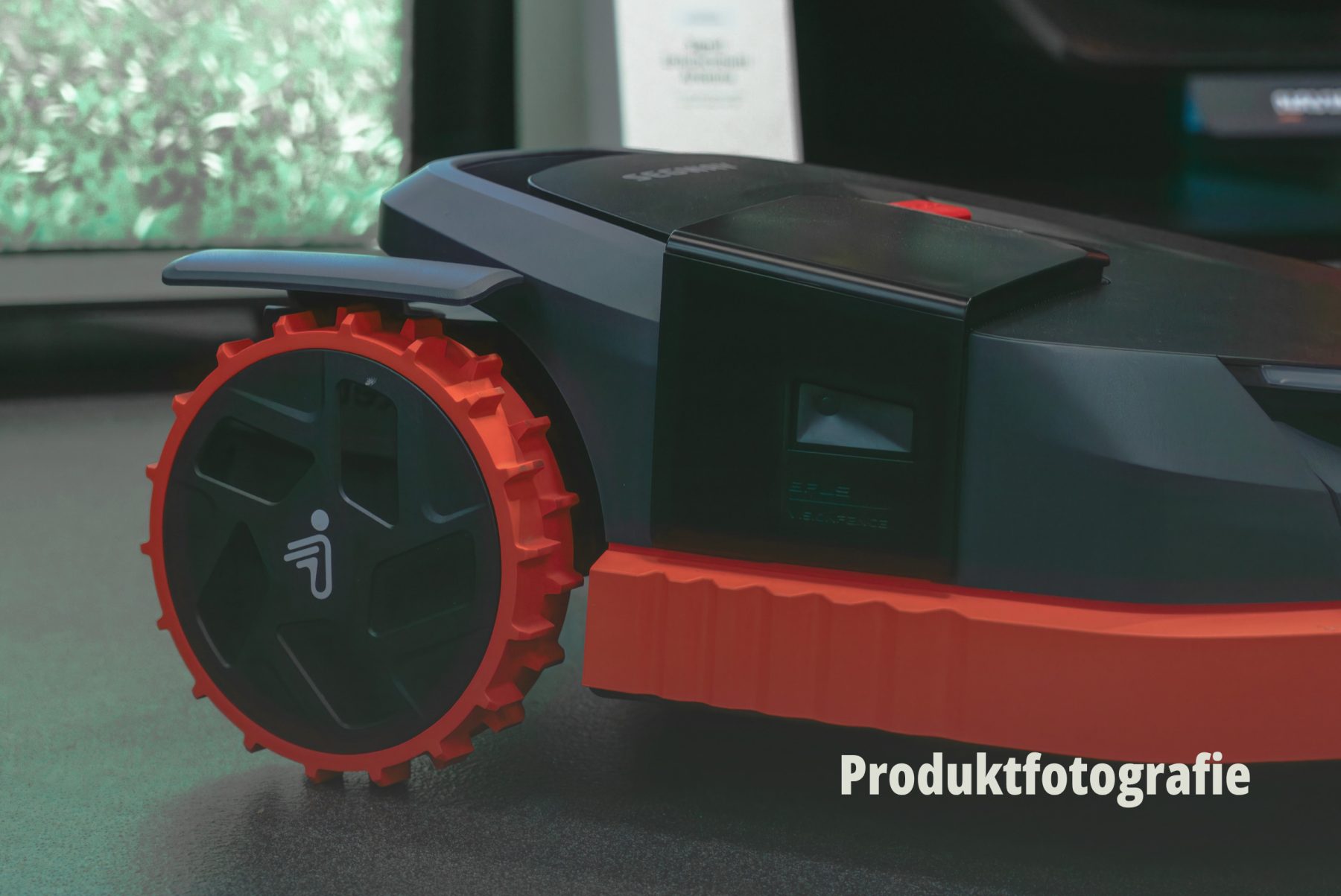 Nahaufnahme eines modernen Mähroboters mit markanten roten Rädern; Detail Produktfotografie von SR-STUDIOS für Web und Social Media der hostettler motoren ag. | SR-STUDIOS