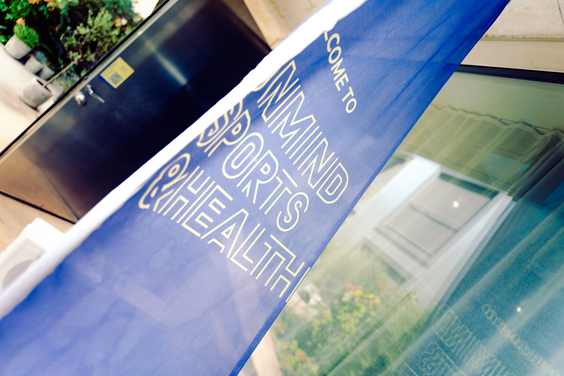 Blaue Fahne im Eingangsbereich mit der Aufschrift «Welcome to OnMind Sports & Health» in den Räumlichkeiten von OnMind Basel während des Social Media Workshops mit SR-STUDIOS. | SR-STUDIOS