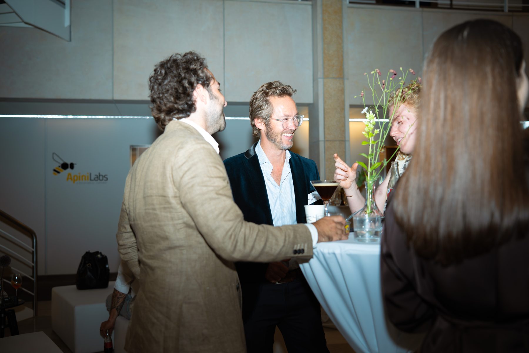 Zwei Männer und eine Frau im Gespräch an einem Stehtisch im Innenbereich des Events. Embrace the taste by SR-STUDIOS. | SR-STUDIOS