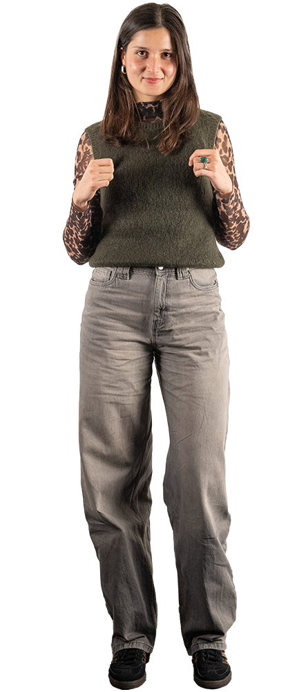 Interne Marketing-Mitarbeiterin mit braunen Haaren trägt grünes ärmelloses Oberteil, steht selbstbewusst für Corporate Branding. | SR-STUDIOS