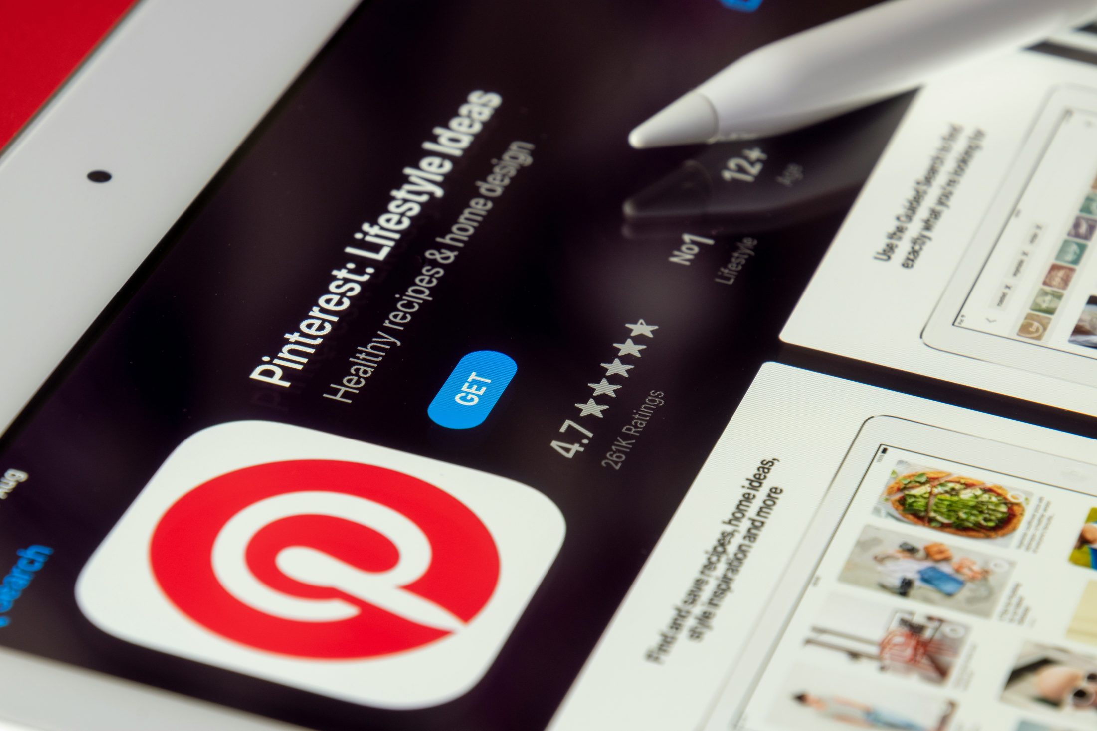 Nahaufnahme eines Tablets mit geöffneter Pinterest-App im App Store. Daneben liegt ein weisser Eingabestift auf dem Bildschirm. | SR-STUDIOS